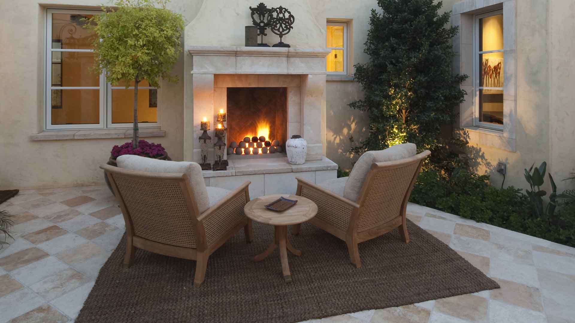 This custom outdoor fireplace adds entertainment space to this Manalapan, FL estate.