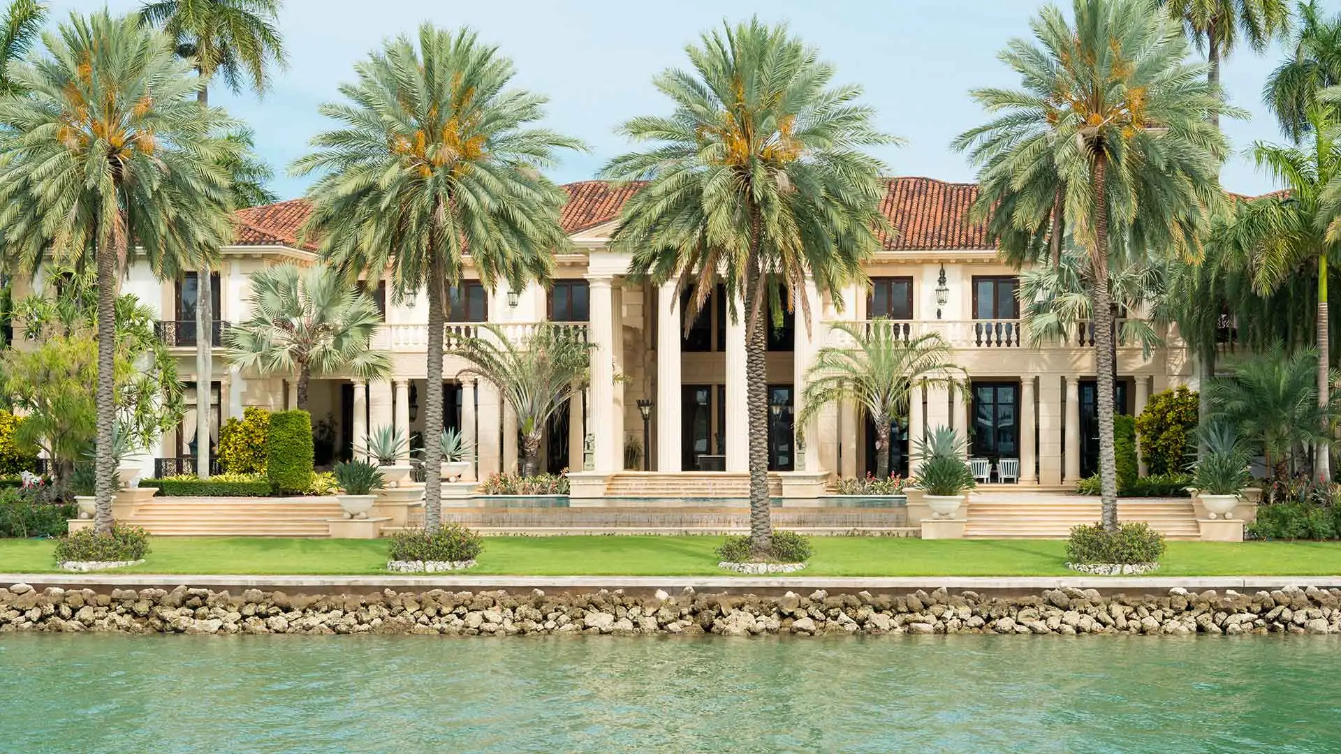 This waterfront estate in Wellington, FL has well-manicured landscaping.